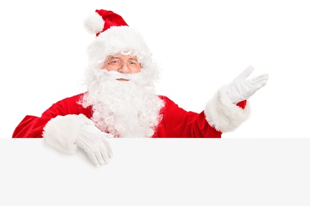 Santa Claus posing behind a blank billboard and gesturing isolated on white backgroundの写真素材