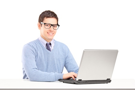Smiling male working on a laptop isolated on white backgroundの写真素材