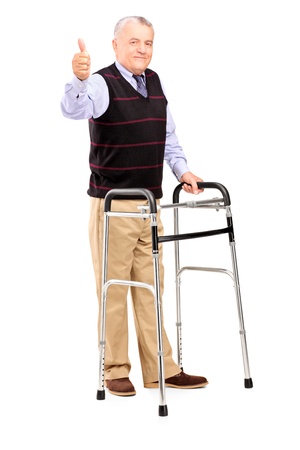 Full length portrait of a mature gentleman using a walker and giving a thumb up isolated on white backgroundの写真素材