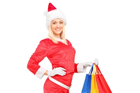A female in christmas costume holding shopping bags isolated on white backgroundの写真素材