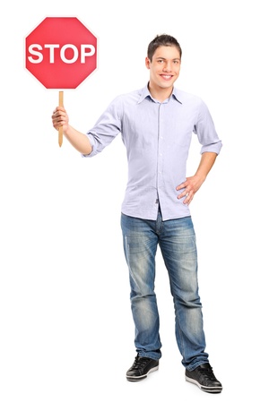 Full length portrait of a man holding a traffic sign stop isolated on white backgroundの写真素材