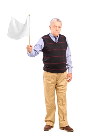 Full length portrait of a sad senior man waving a white flag isolated on white backgroundの写真素材