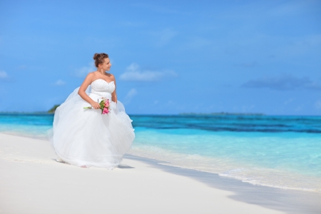 Bride watching towards the see on an exotic beach in Maldivesの写真素材