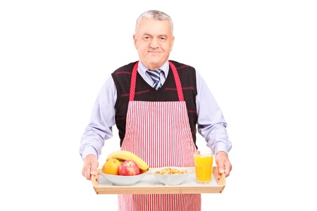 A smiling gentleman in apron carrying a tray with drinks and food isolated against white background