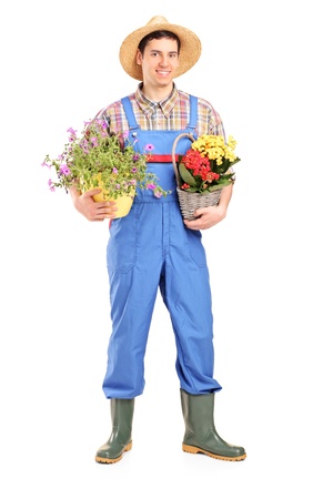 Full length portrait of a male gardener holding plants isolated on white backgroundの写真素材