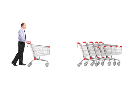 Full length portrait of a man returning an empty shopping cart isolated on white backgroundの写真素材
