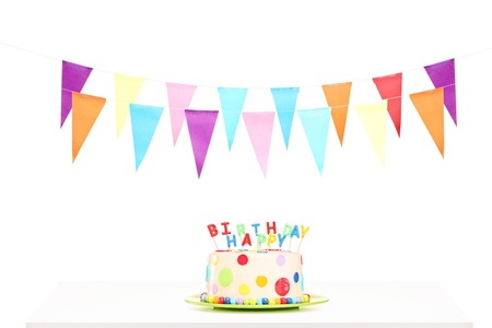Colorful party flags and a birthday cake, isolated against white background の写真素材