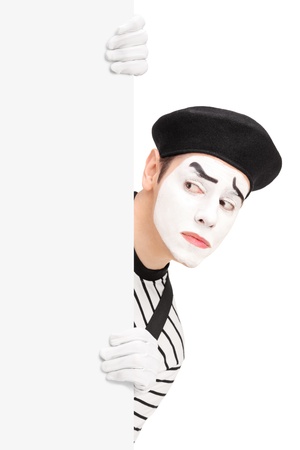 A mime artist behind a blank panel making a grimace, isolated on white backgroundの写真素材