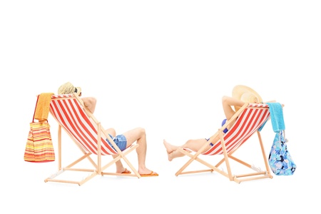 Couple relaxing on a sun loungers, isolated on white backgroundの写真素材
