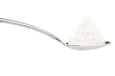 Sugar cubes on a metal spoon isolated on white backgroundの写真素材