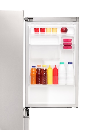 Close up of an open fridge full of healthy food products isolated on white backgroundの写真素材