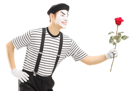 Male mime artist giving a rose flower isolated on white backgroundの写真素材