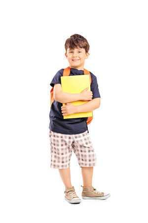 Schoolboy with backpack holding a notebook isolated on white backgroundの写真素材