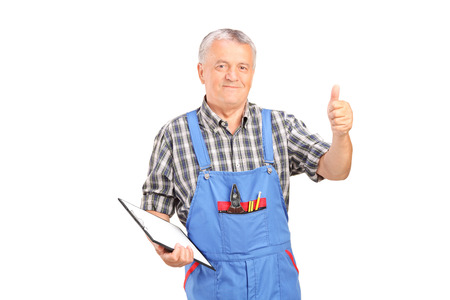 Male mechanic holding clipboard and giving thumb up isolated on white backgroundの写真素材