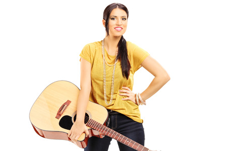 Female musician holding an acoustic guitar isolatedの写真素材