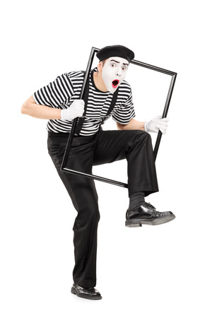 Male mime artist walking through a metal frame isolated on white backgroundの写真素材