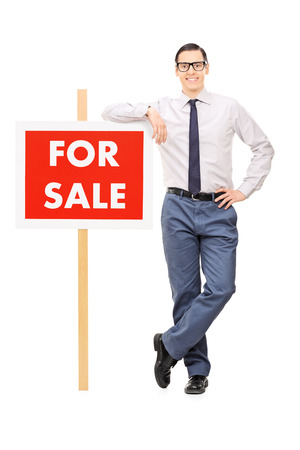 Man leaning on a for sale sign isolated on white backgroundの写真素材