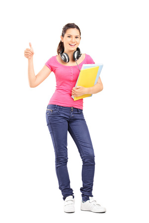 Full length portrait of a young female student giving thumb up isolated の写真素材