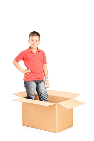 Little boy standing in a carton box isolatedの写真素材