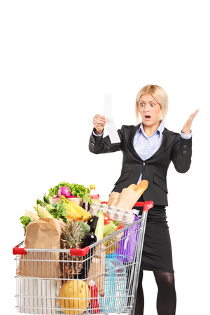 Formal woman looking at the shopping bill in disbelief isolated on white backgroundの写真素材