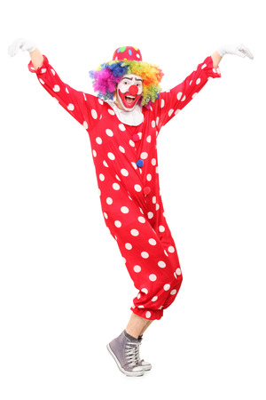 Full length portrait of a happy male clown dancing isolated on white backgroundの写真素材