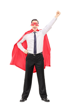 Full length portrait of a superhero with raised fist isolated on white backgroundの写真素材