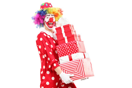 Male clown carrying a pile of gifts isolated on white backgroundの写真素材