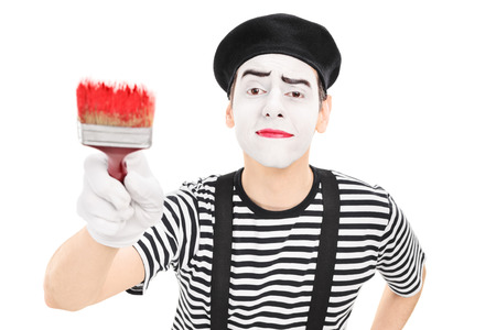 Mime artist holding a paintbrush isolated against white backgroundの写真素材