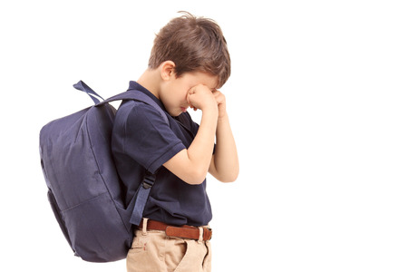 Schoolboy crying, isolated on white backgroundの写真素材