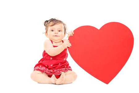 Cute little baby holding a big red heart isolated on white backgroundの写真素材
