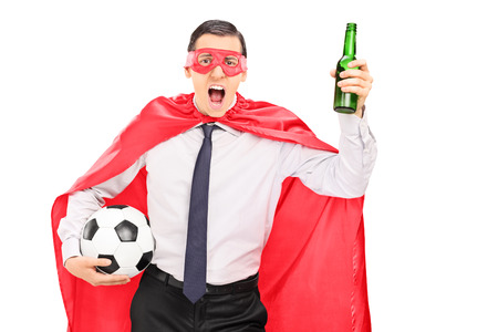 Superhero holding a football and cheering isolated on white backgroundの写真素材