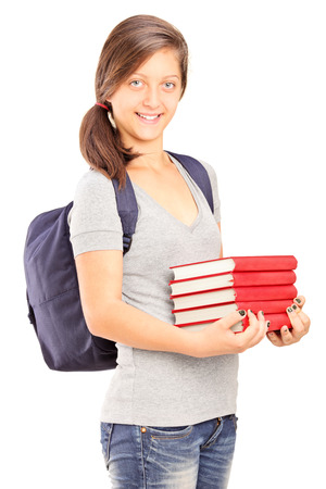 Young schoolgirl holding a pile of books isolated on white backgroundの写真素材
