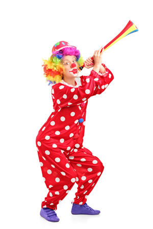 Female clown blowing a horn isolated on white backgroundの写真素材