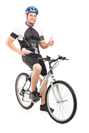 Male biker sitting on his bike and holding a water bottle isolated on white backgroundの写真素材