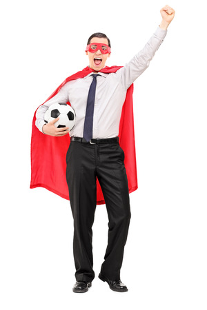 Man in superhero costume holding a football isolated on white backgroundの写真素材