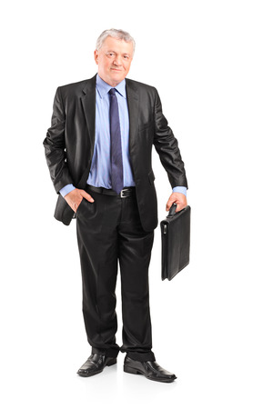 Full length portrait of a mature businessman holding a briefcase isolated on white backgroundの写真素材