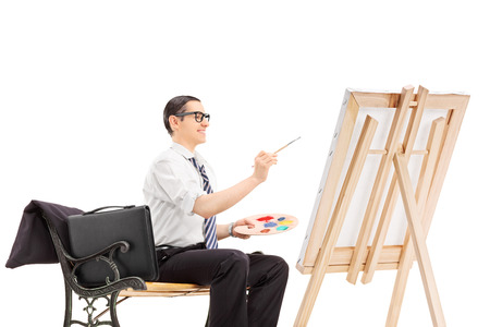 Male businessman painting on a canvas isolated on white backgroundの写真素材