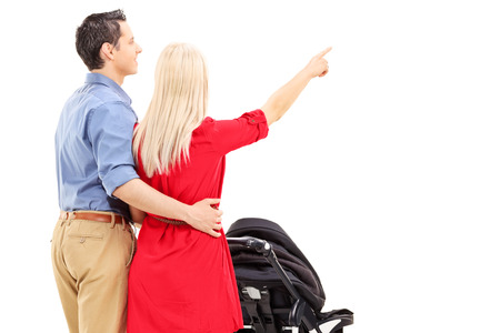 Mother and father pushing a baby stroller isolated against white background, rear viewの写真素材