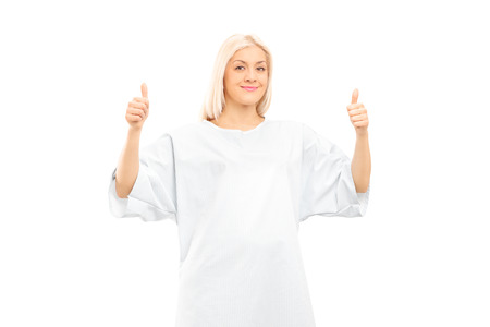 Female patient giving thumbs up isolated on white backgroundの写真素材