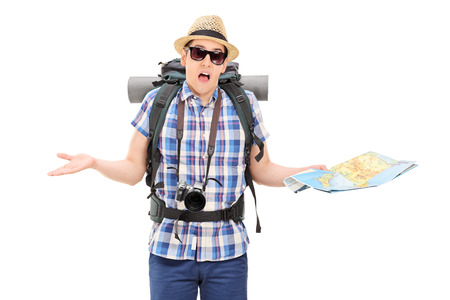 Lost male tourist holding a map and gesturing with hands isolated on white background Lost male tourist holding a map and gesturing with hands isolated on white background