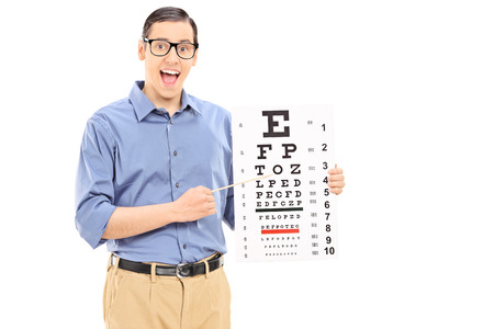 Excited young man pointing on an eye chart with wooden stick isolated on white background