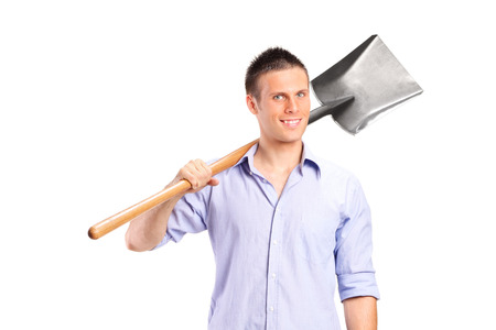 Young man holding a shovel isolated on white backgroundの写真素材