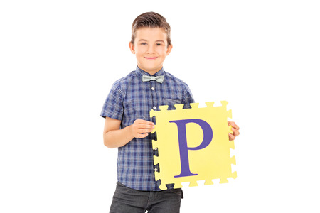 Male kid holding a piece of a puzzle isolated on white backgroundの写真素材