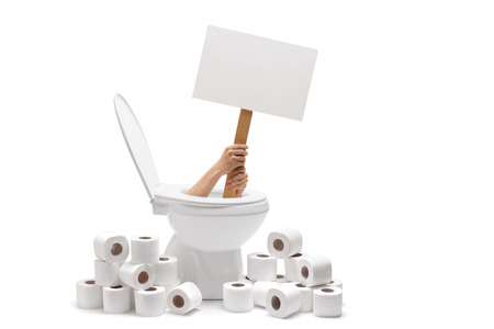 Hands holding a blank banner from a toilet with a pile of toilet paper around isolated on white backgroundの写真素材