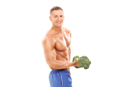 Male bodybuilder holding a broccoli dumbbell isolated on white backgroundの写真素材