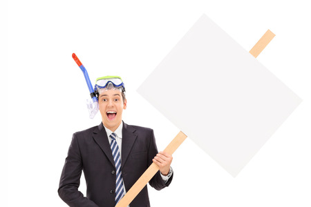 Businessman with diving mask holding blank signboard isolated on white backgroundの写真素材