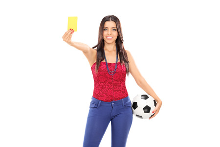Female football fan showing a yellow card isolated on white backgroundの写真素材