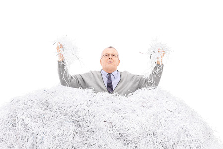 Desperate senior holding a bunch of shredded paper isolated on white background