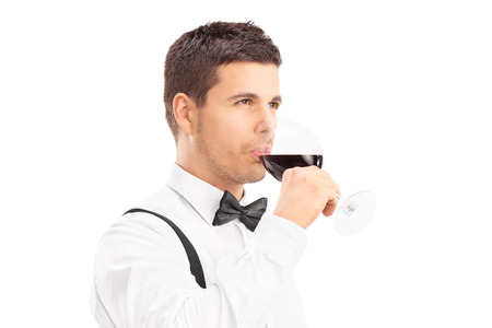 Young man enjoying a glass of red wine isolated on white backgroundの写真素材