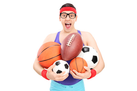 Nerdy guy holding a bunch of sports balls isolated on white backgroundの写真素材